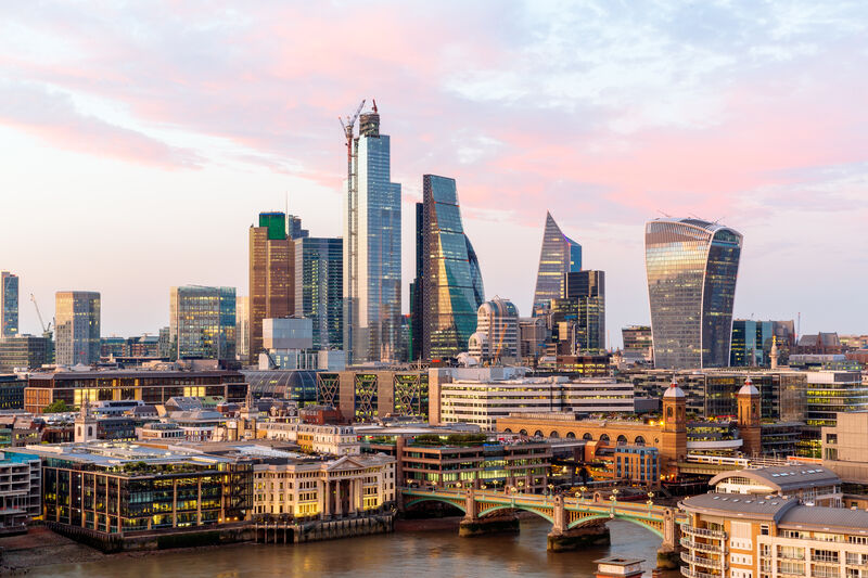 London city skyline at sunset, featuring modern skyscrapers in the financial district along the River Thames.